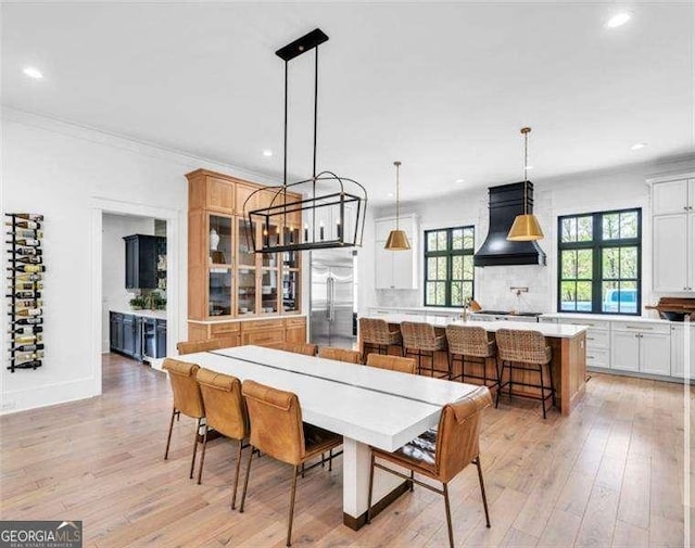 dining area featuring crown molding, recessed lighting, and light wood-style flooring