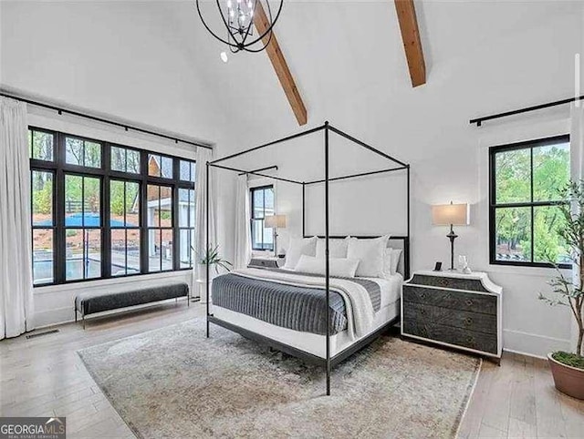 bedroom featuring beam ceiling, wood finished floors, high vaulted ceiling, and multiple windows