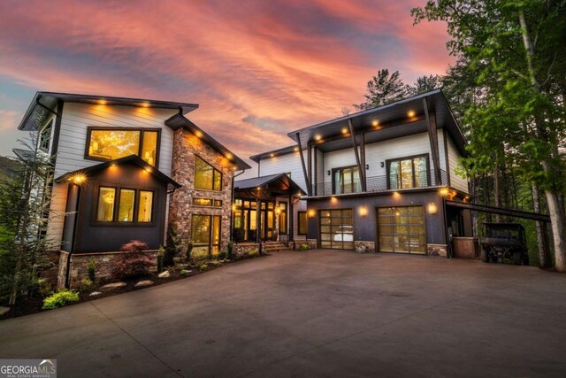 51 Birdseye Vw, Blue Ridge, GA 30513 - back of house at dusk featuring stone siding, driveway, and an attached garage