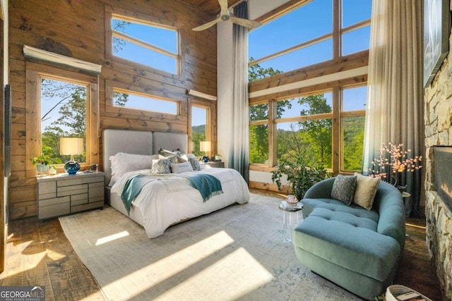 51 Birdseye Vw, Blue Ridge, GA 30513 - bedroom featuring multiple windows, wood walls, a warm lit fireplace, and a towering ceiling