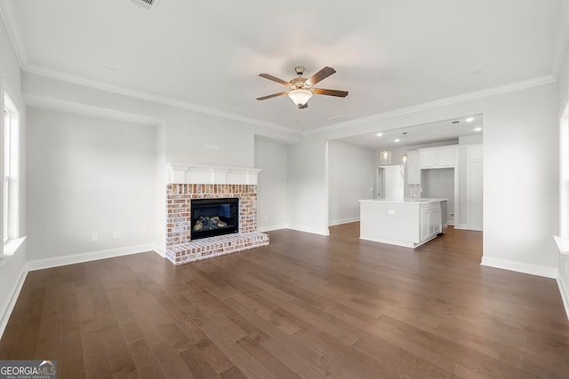 unfurnished living room featuring baseboards, a brick fireplace, ceiling fan, and dark wood-type flooring