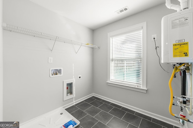 laundry area featuring laundry area, hookup for an electric dryer, dark tile patterned floors, baseboards, and hookup for a washing machine