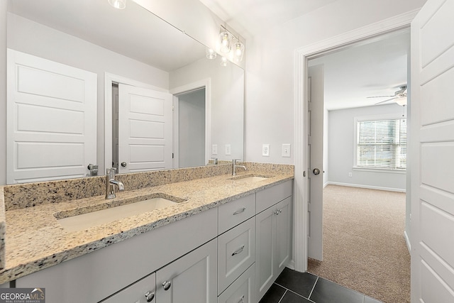 bathroom featuring double vanity, tile patterned floors, baseboards, and a sink