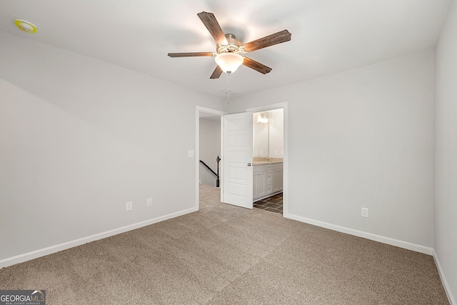 unfurnished bedroom with ceiling fan, ensuite bathroom, carpet, and baseboards