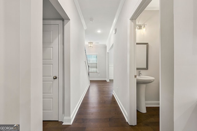 corridor with a sink, crown molding, dark wood finished floors, baseboards, and recessed lighting