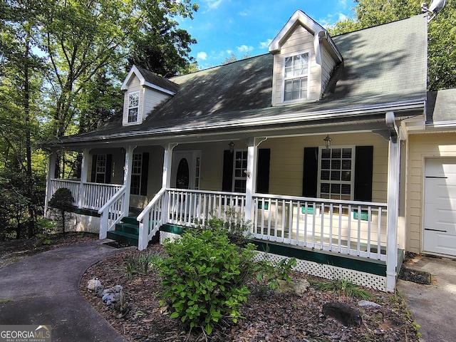 cape cod home with a porch and roof with shingles