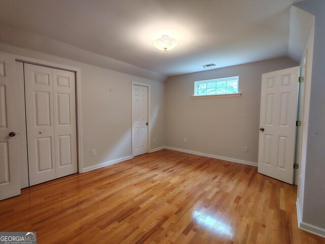 unfurnished bedroom featuring visible vents, light wood-style flooring, and baseboards