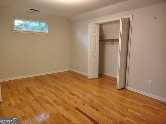 unfurnished bedroom featuring light wood finished floors, a closet, visible vents, and baseboards