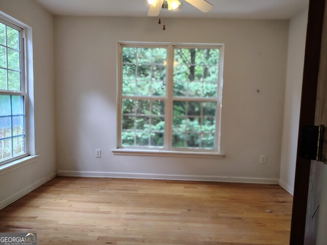 unfurnished room with a ceiling fan, baseboards, light wood-style flooring, and plenty of natural light