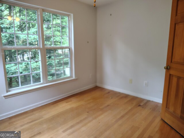 unfurnished room featuring baseboards and light wood-type flooring
