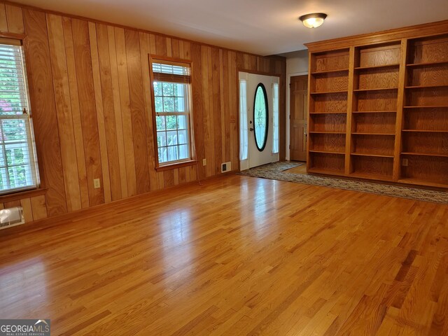 interior space with wood walls, visible vents, and wood finished floors
