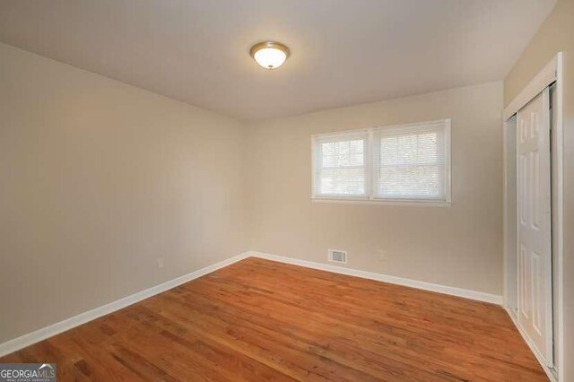 6575 Wendell Cir, Morrow, GA 30260 - unfurnished bedroom featuring baseboards, a closet, visible vents, and wood finished floors