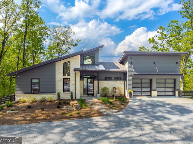 377 Charmont Dr, Tiger, GA 30576 - view of front of home with stone siding, a garage, driveway, and fence