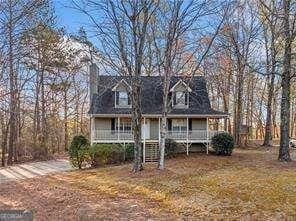 cape cod home featuring covered porch