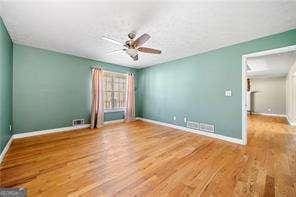 spare room with ceiling fan, baseboards, and wood finished floors