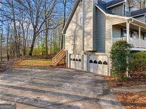 view of home's exterior featuring driveway, stairway, and an attached garage
