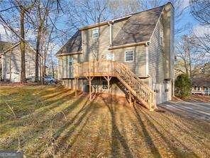 rear view of property with stairway and a wooden deck