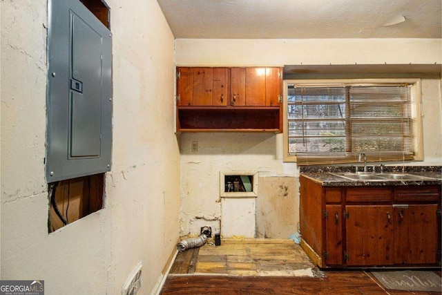 1491 Boulderwoods Dr, Atlanta, GA 30316 - kitchen with a sink, electric panel, dark wood-type flooring, brown cabinets, and dark countertops