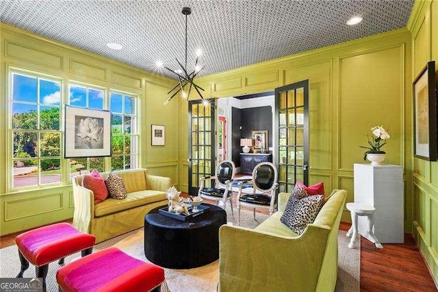 13922 Tree Loft Rd, Milton, GA 30004 - living area with a decorative wall, french doors, a notable chandelier, and wood finished floors