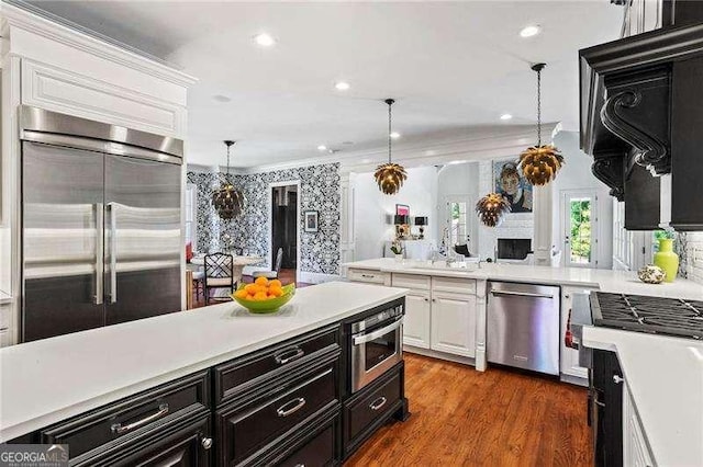 13922 Tree Loft Rd, Milton, GA 30004 - kitchen with pendant lighting, stainless steel appliances, white cabinetry, dark wood-type flooring, and light countertops