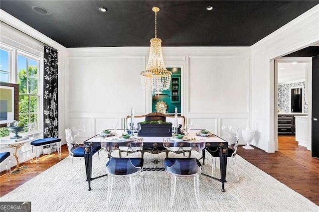 13922 Tree Loft Rd, Milton, GA 30004 - dining area featuring wood finished floors, a chandelier, a decorative wall, and ornamental molding