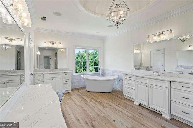 13922 Tree Loft Rd, Milton, GA 30004 - bathroom with a sink, visible vents, a freestanding tub, a chandelier, and ornamental molding