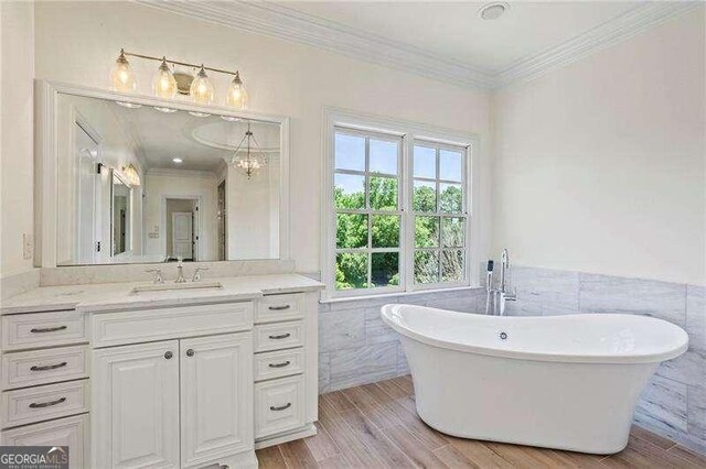 13922 Tree Loft Rd, Milton, GA 30004 - bathroom featuring a soaking tub, tile walls, vanity, and crown molding