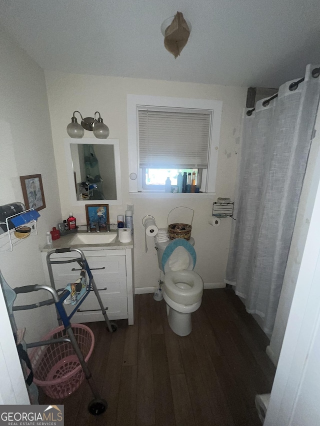 1621 Lee St, Brunswick, GA 31520 - full bath with wood finished floors, toilet, vanity, curtained shower, and baseboards