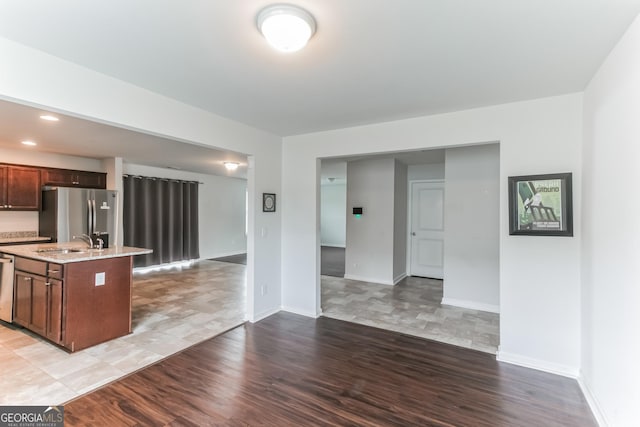 62 Blackberry Cir, Guyton, GA 31312 - kitchen with wood finished floors, a sink, open floor plan, a center island with sink, and appliances with stainless steel finishes