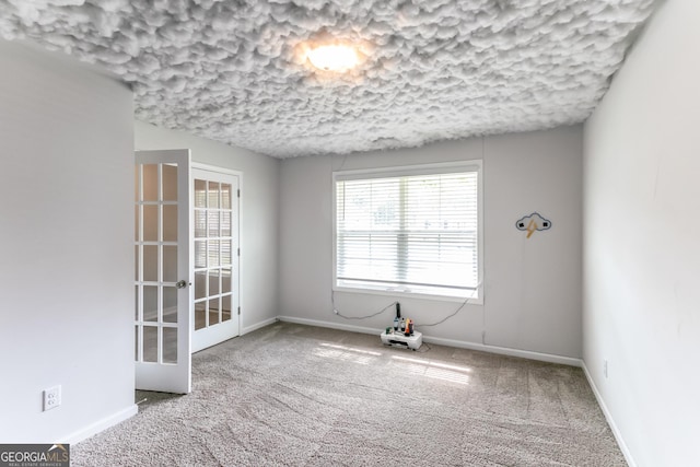 62 Blackberry Cir, Guyton, GA 31312 - empty room with a textured ceiling, carpet, baseboards, and french doors