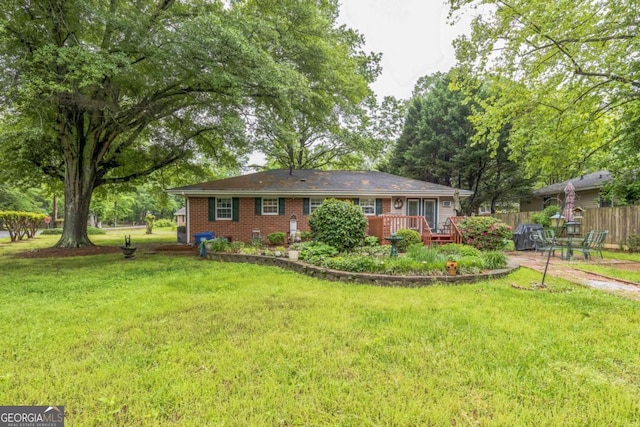 292 Lumpkin St, Winder, GA 30680 - single story home with brick siding, a wooden deck, fence, and a front yard
