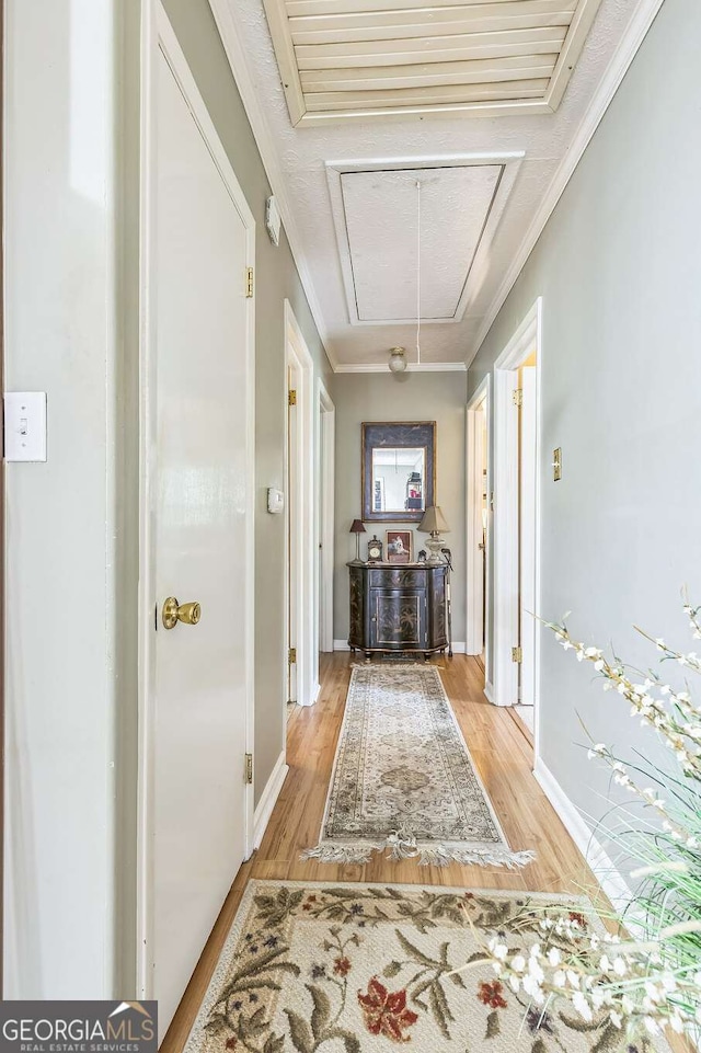292 Lumpkin St, Winder, GA 30680 - hallway featuring ornamental molding, light wood-style flooring, attic access, and baseboards
