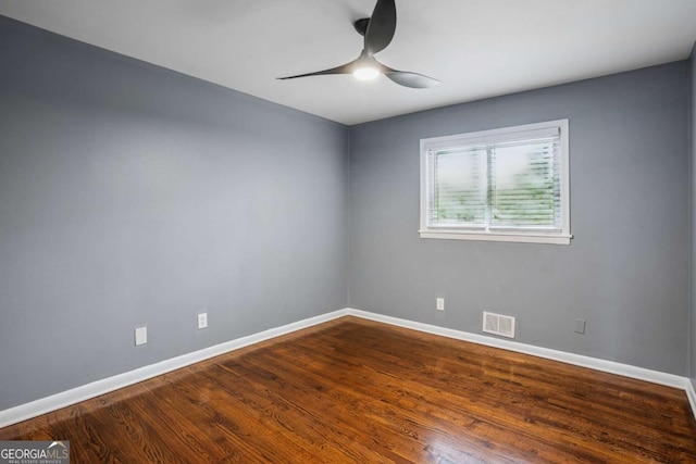 spare room featuring baseboards, a ceiling fan, visible vents, and wood finished floors