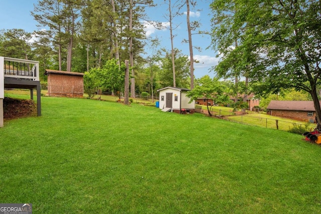 view of yard with an outdoor structure, a fenced backyard, and a storage unit