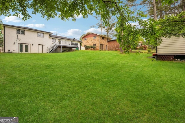 view of yard featuring french doors, a wooden deck, and stairs