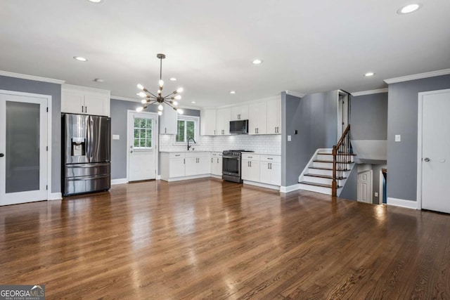 unfurnished living room with a notable chandelier, recessed lighting, and a sink