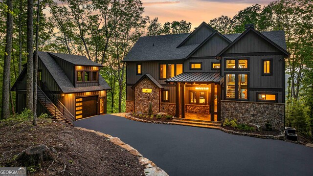 modern farmhouse style home with roof with shingles, a standing seam roof, and stone siding