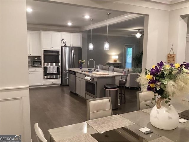 100 Ruby Ln, Mcdonough, GA 30252 - kitchen with appliances with stainless steel finishes, a sink, white cabinets, a kitchen island with sink, and hanging light fixtures