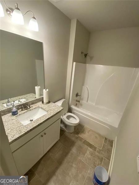 100 Ruby Ln, Mcdonough, GA 30252 - bathroom featuring shower / tub combination, toilet, and vanity