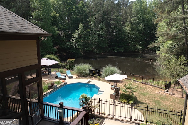 view of swimming pool with a water view, a patio area, a diving board, and fence