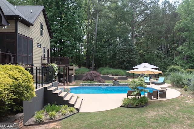 outdoor pool featuring stairs, a patio, a wooden deck, and a lawn