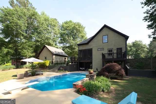 pool featuring stairs, a wooden deck, a patio area, and a lawn
