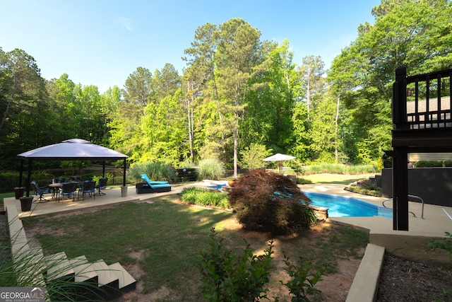 outdoor pool with a wooded view and a patio