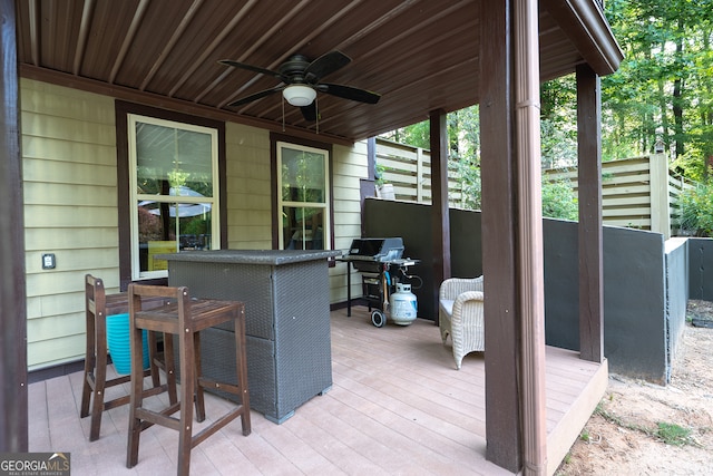 view of patio with ceiling fan, a deck, and grilling area