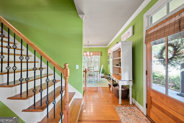 interior space featuring ornamental molding, an inviting chandelier, and wood-type flooring