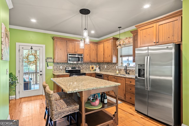 kitchen featuring decorative backsplash, stainless steel appliances, light wood-style flooring, and a sink