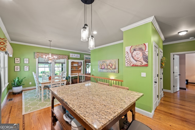 kitchen featuring light stone countertops, baseboards, light wood finished floors, an inviting chandelier, and a kitchen breakfast bar
