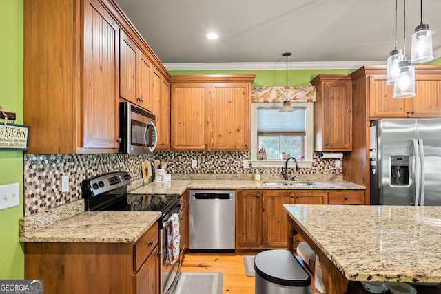 kitchen featuring brown cabinets, a sink, decorative light fixtures, appliances with stainless steel finishes, and light stone counters