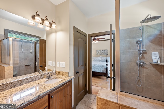 bathroom featuring ensuite bathroom, ceiling fan, tile patterned flooring, tiled shower, and vanity