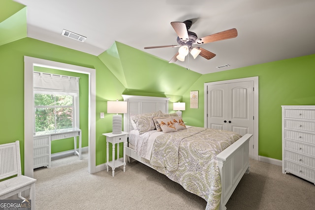 carpeted bedroom featuring vaulted ceiling, a closet, visible vents, and baseboards